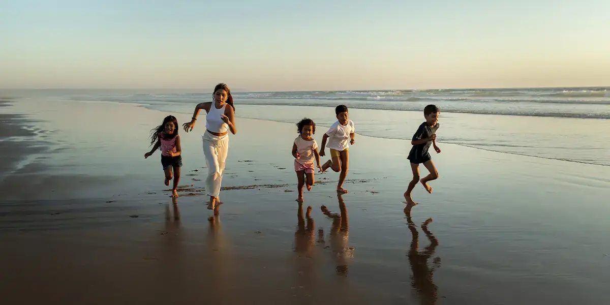 Enfants qui courent sur la plage en vacances petits budgets