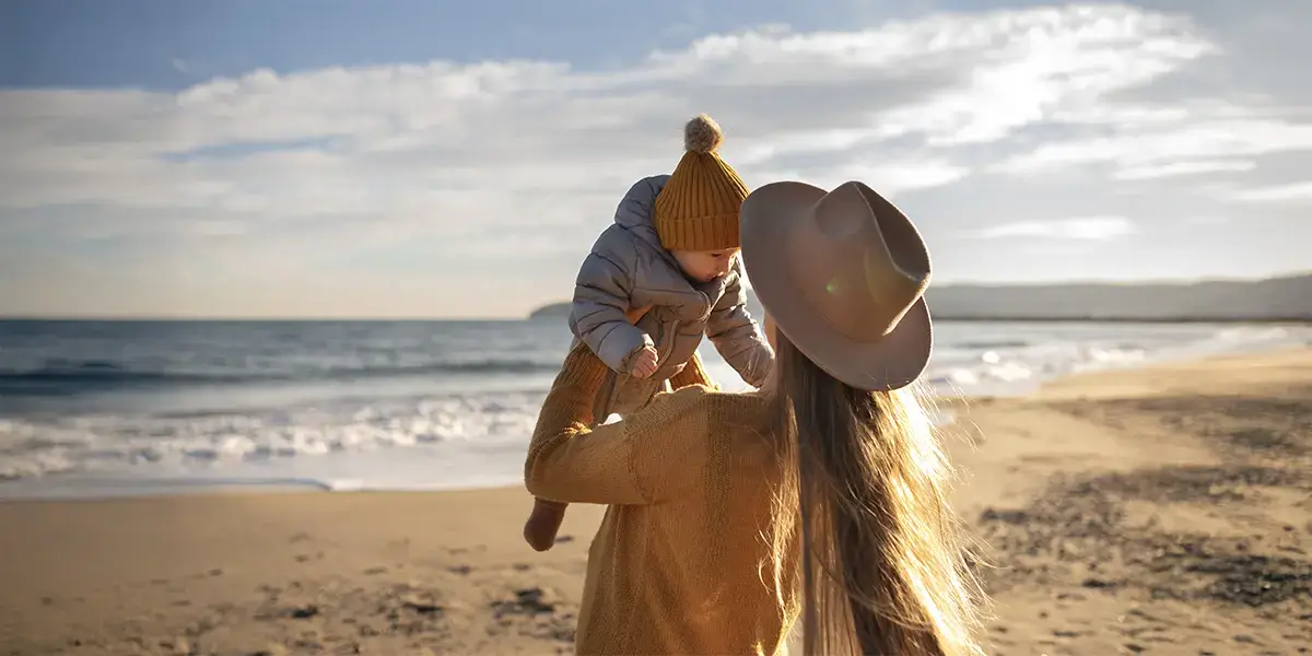 Maman et son bébé sur la plage en vacances petit budget avec VTF association du tourisme social et solidaire