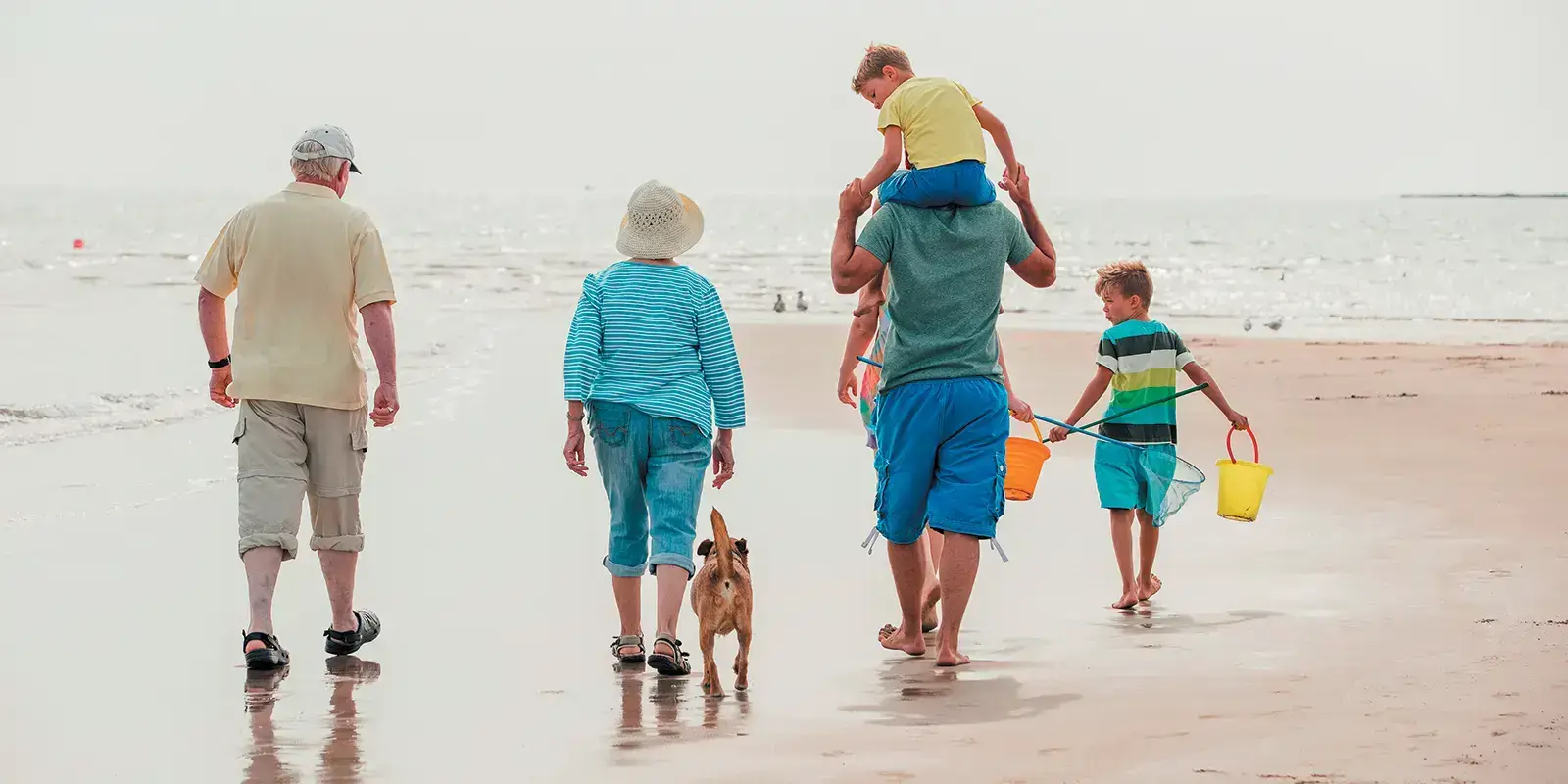 Famille intergénérationnelle sur la plage en vacances vtf
