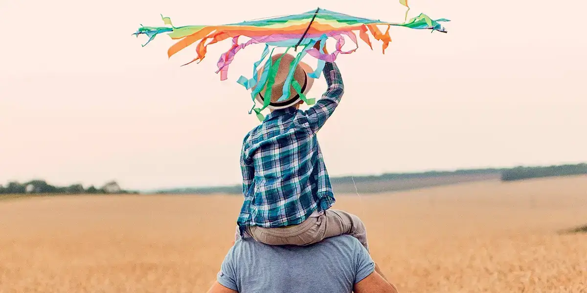 Enfant jouant sur le dos de son père en vacances pas cher VTF