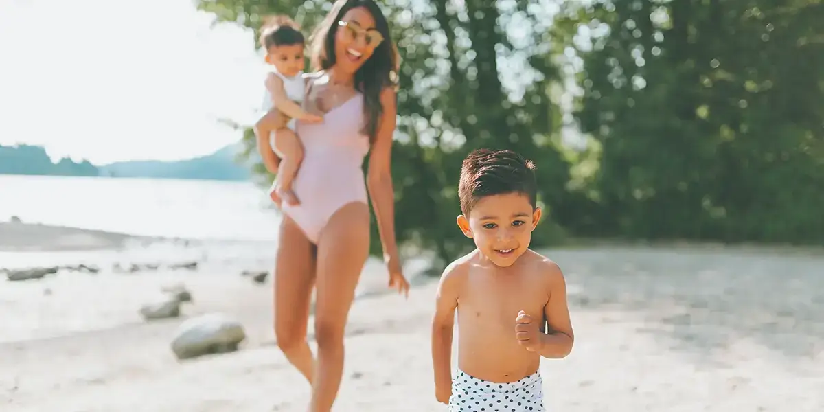 Maman et ses enfants marchant sur la plage près d'un vtf