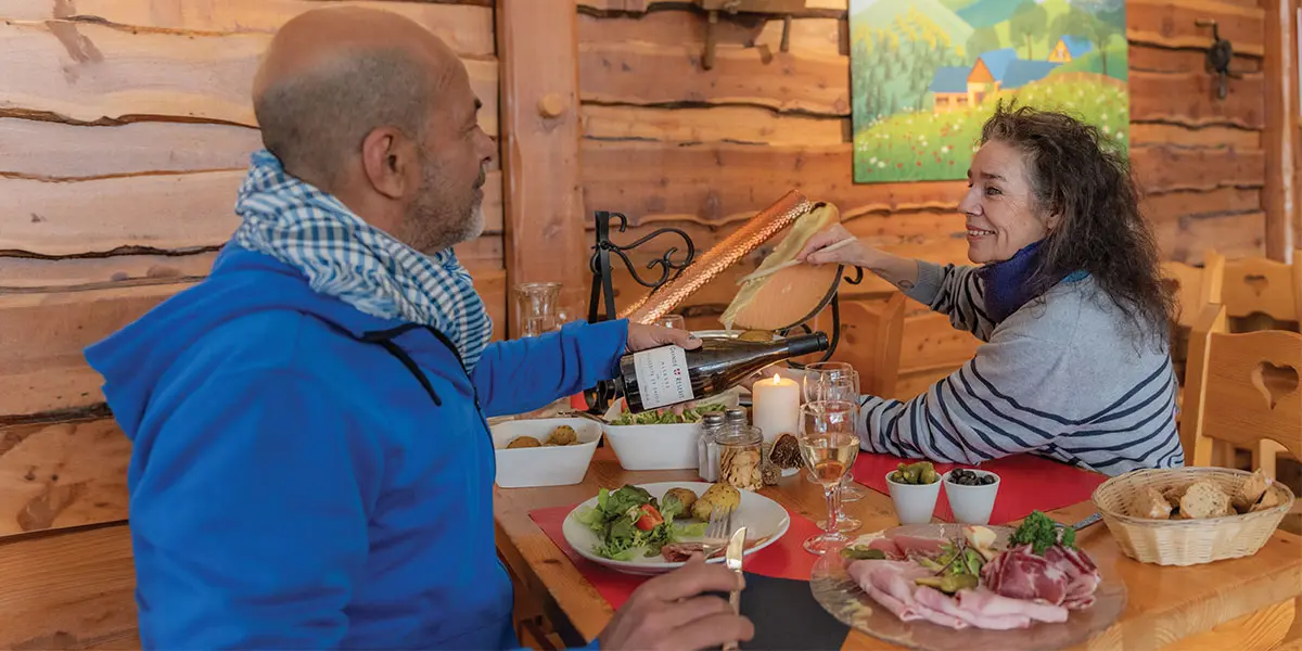 Couple profitant d'une raclette en vacances dans un village vacances VTF