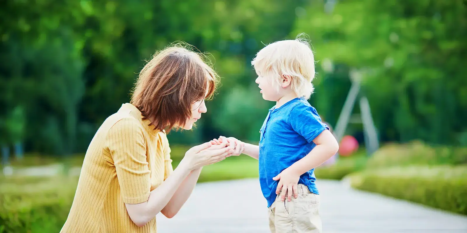 Maman soigne la main de son enfant dans un parc en vacances VTF