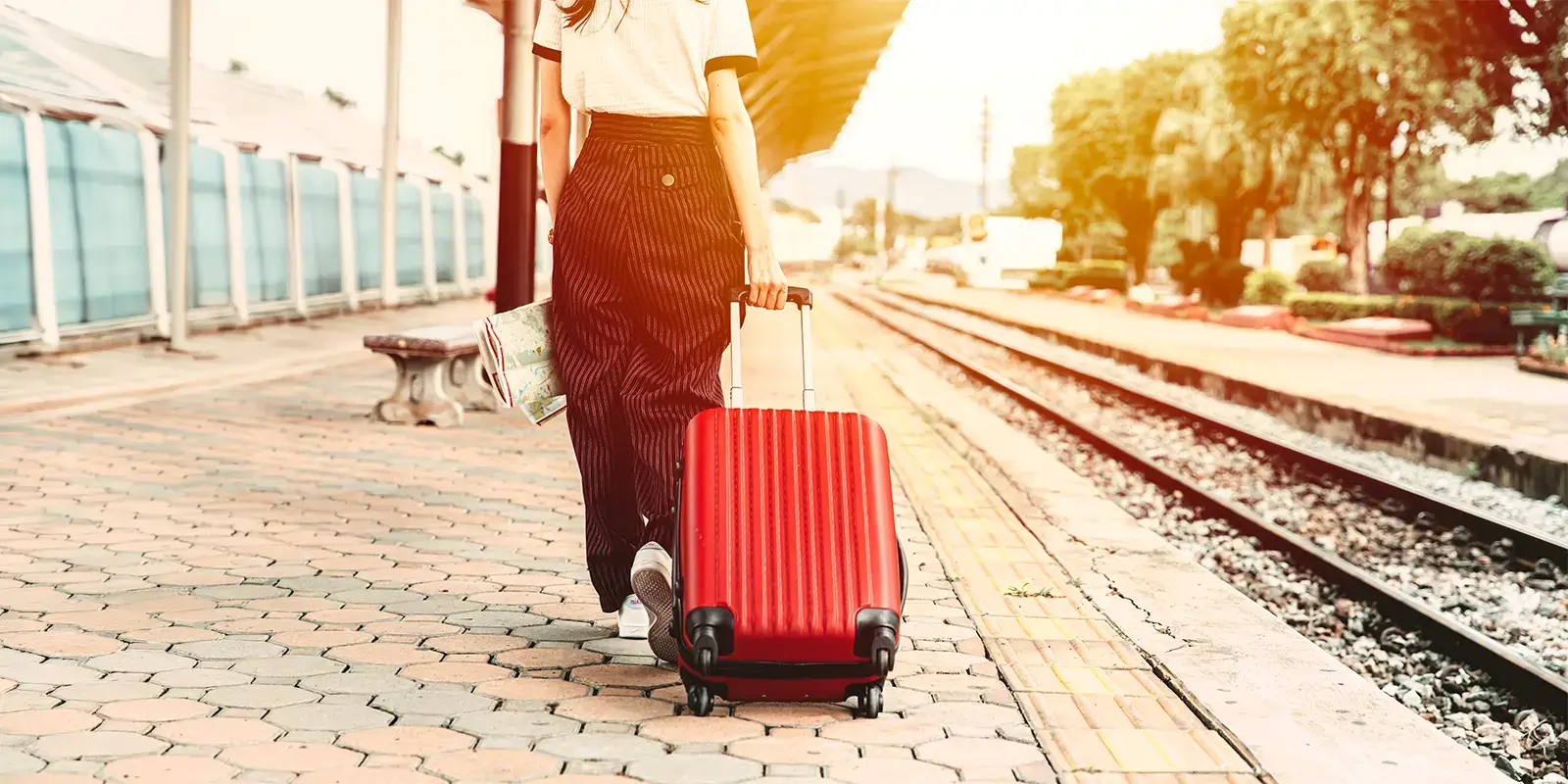 Femme sur le quai d'une gare avec sa valise pour ses vacances avec VTF