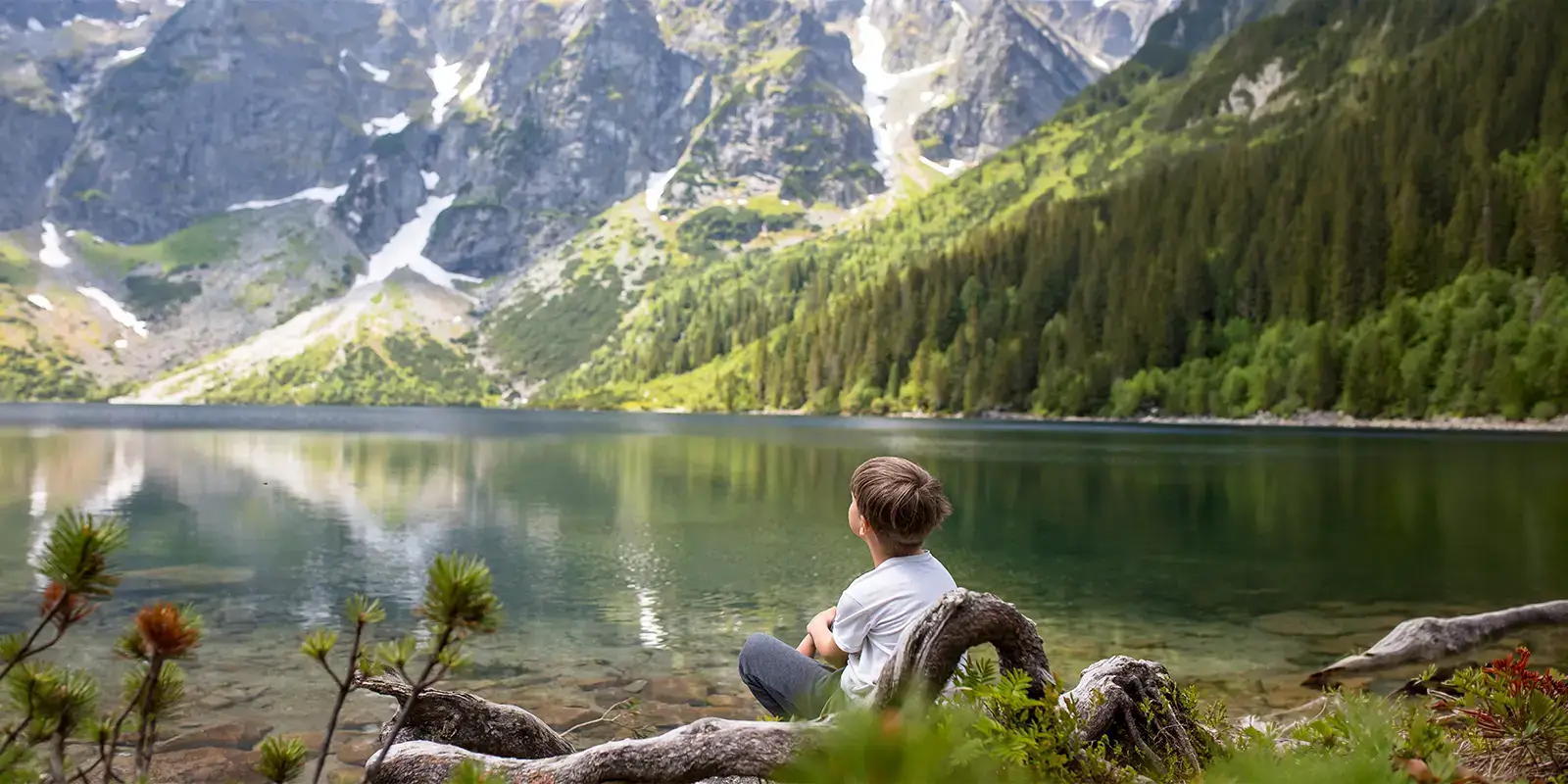 Enfant en vacances au bord d'un lac de montagne