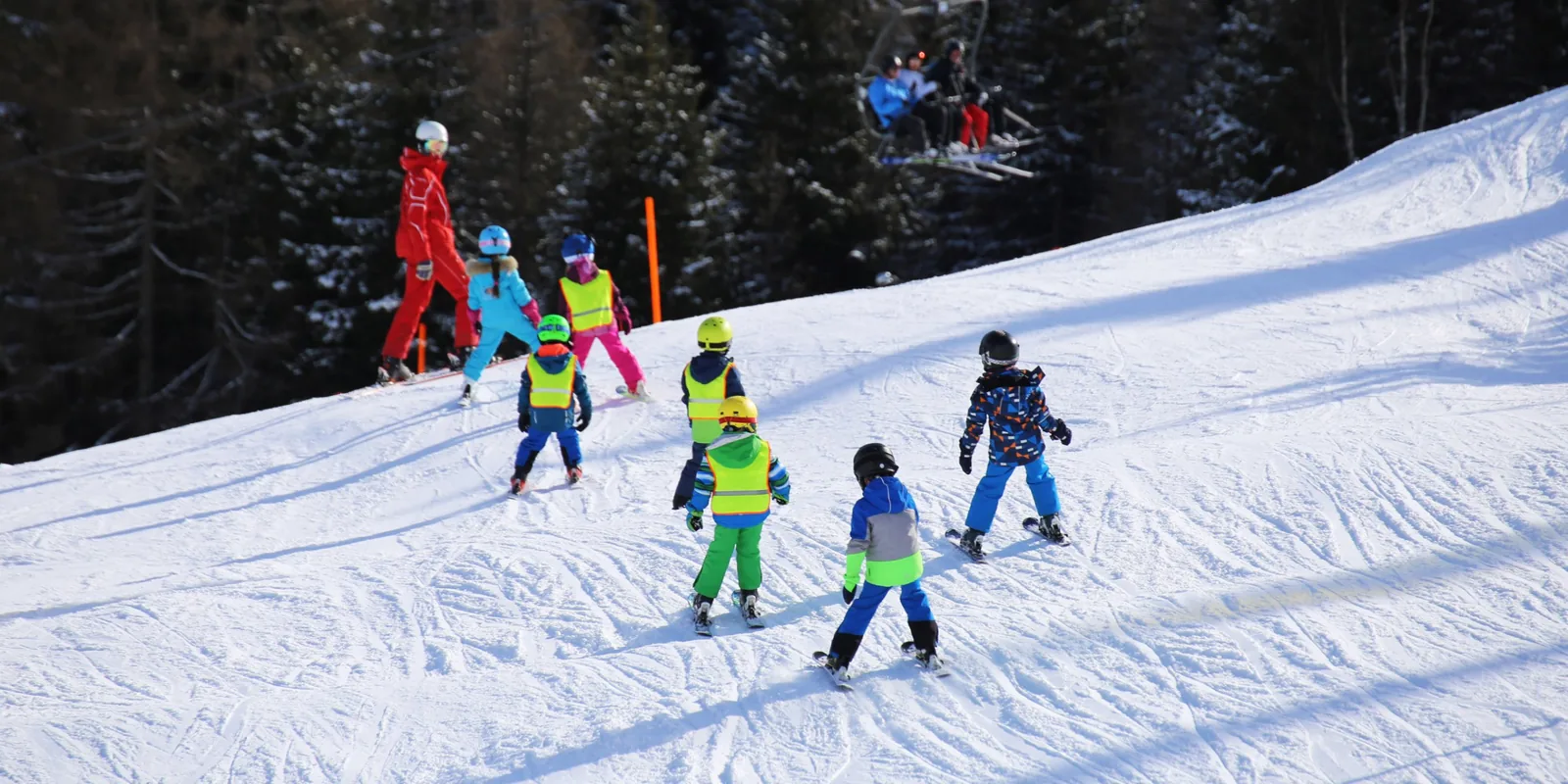 Moniteur de ski encadrant un groupe d'enfants qui apprennent à skier