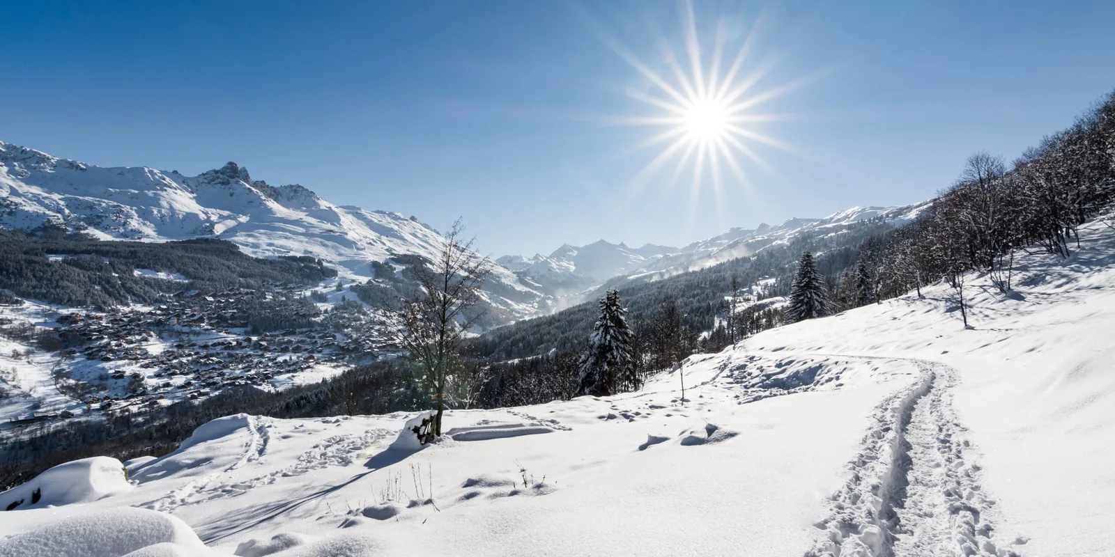 Sentier enneigé au soleil avec vue sur la vallée de la Tarentaise près de Doucy