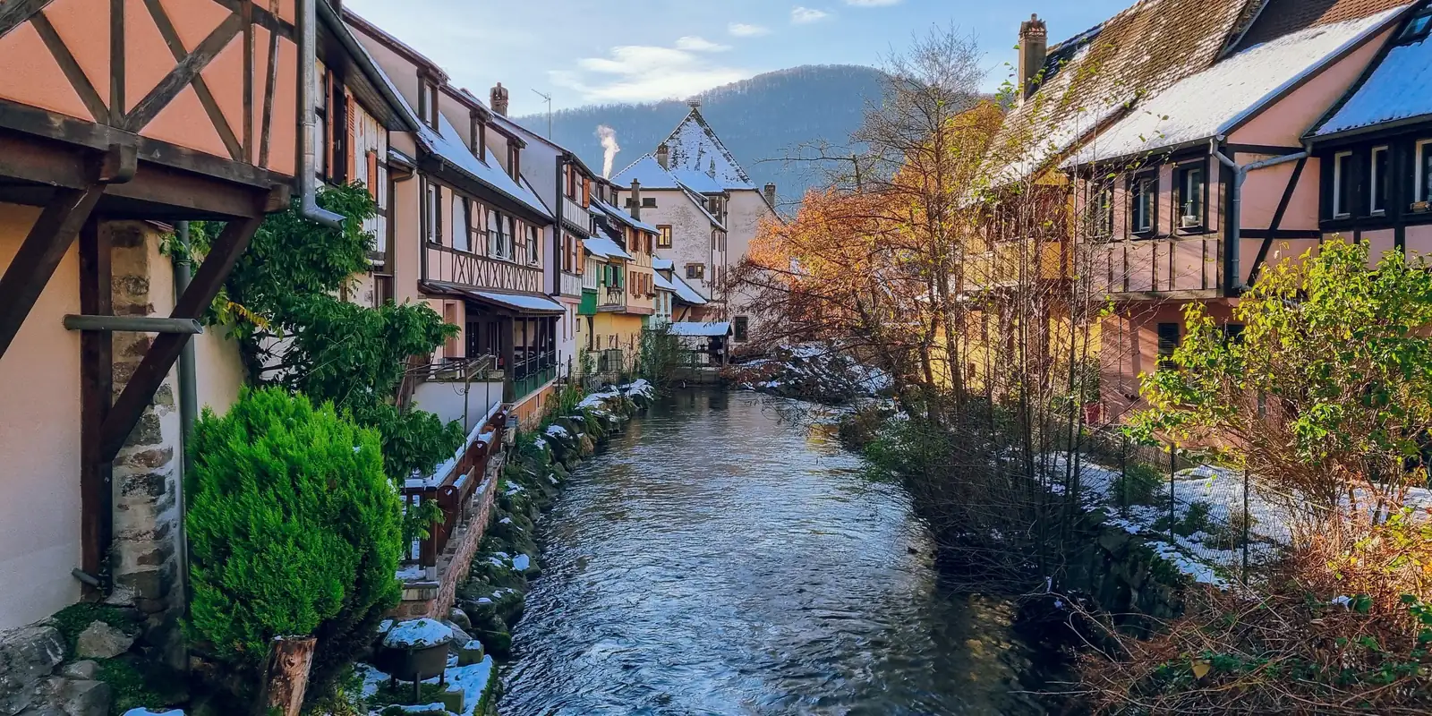 Maisons à colombages au bord de l'eau dans un village d'Alsace en hiver
