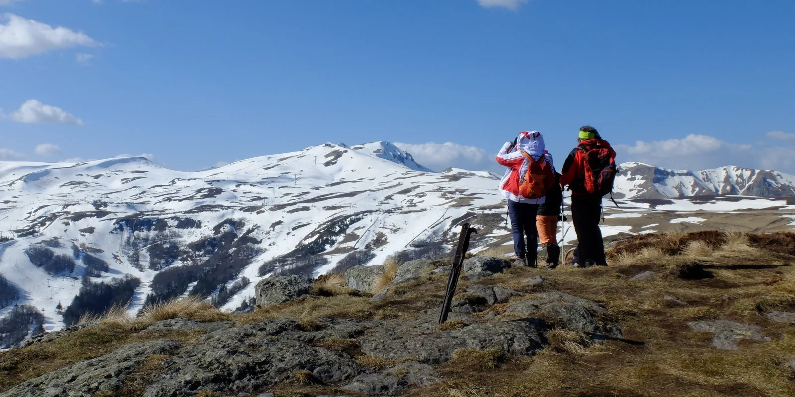 Randonneurs face aux sommets enneigés du massif du Sancy en Auvergne